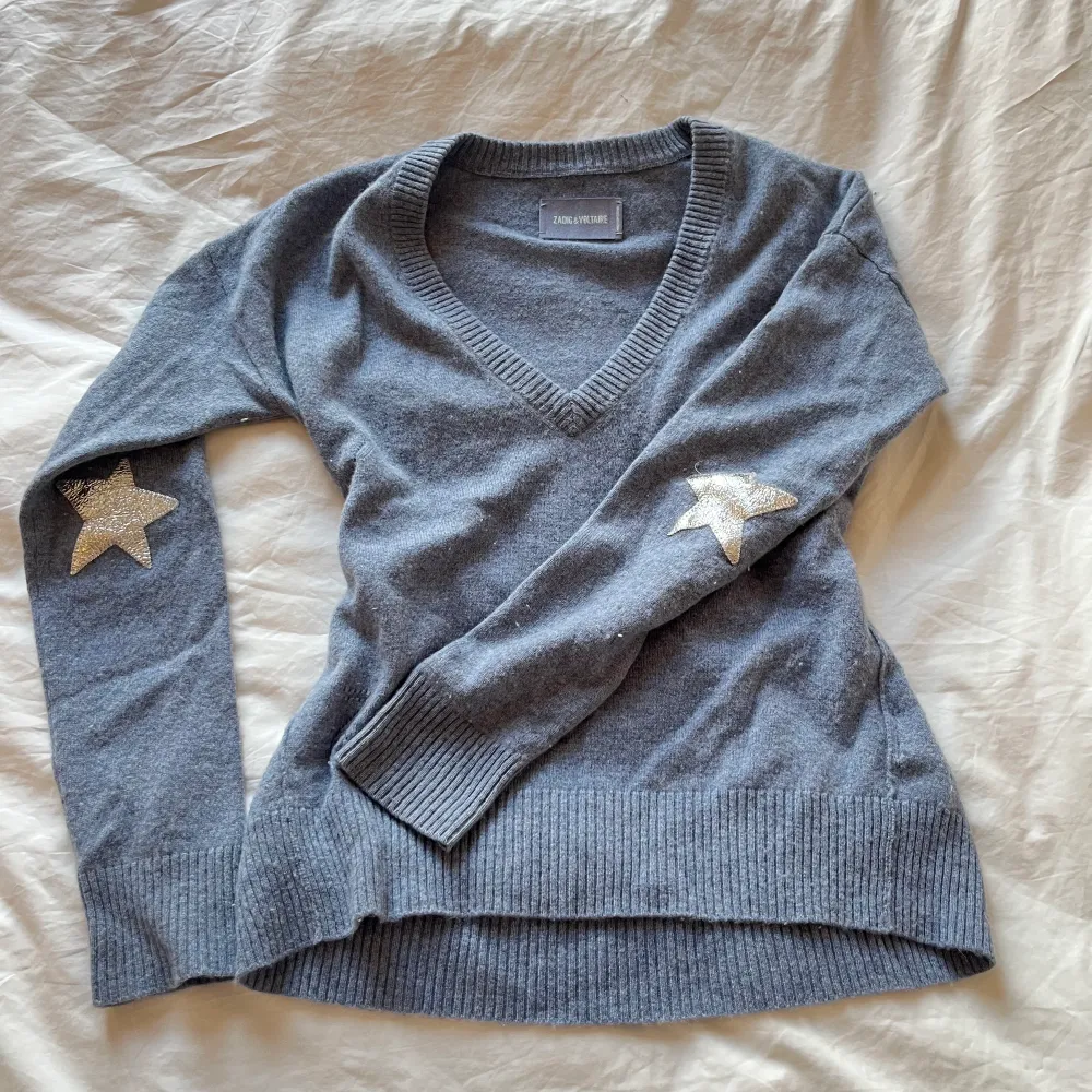 Ljusblå v-ringad tröja från zadig & voltaire med stjärnor på ärmarna i silver metallic. Använd fåtal gånger! Går inte att få tag på längre! . Stickat.