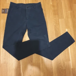 Oscar Jacobson marinblå dam chinos strl 34 - Oscar Jacobson marinblå dam chinos storlek 34, oanvända! Helt nya! Modell Maria trousers. Nypris ca 1800:-