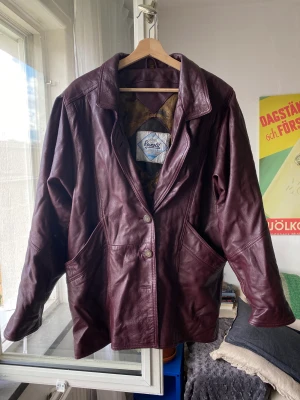 Läderkappa/skinnkappa - Säljer min fina fina vinröda läderjacka, superfin färg och rätt varm! Bra höstjacka  Storlek 46 och sitter oversize på mig som är 173cm, fler bilder finns om så önskas!