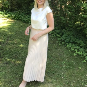 Plisserad kjol Selected Femme - Krämfärgad plisserad kjol från Selected Femme, använd ett fåtal gånger. Nypris 800kr