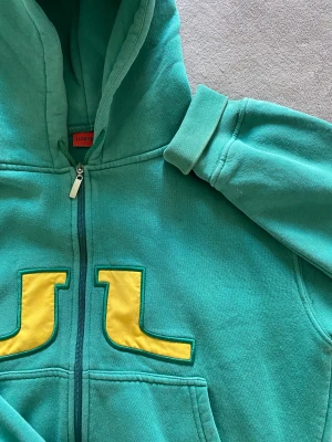 Vintage J.linderberg hoodie - En jätte fin vintage j.linderberg tröja med luva i färgerna grön & gul! Super skön och bra skick