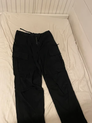 Svarta Cargo Byxor - Svarta byxor, inget slitage som jag ser, nästan oanvända 