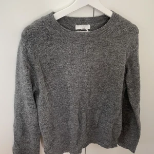 Grå stickad tröja - I tunt material. Använd men fint skick.