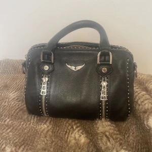 Zadig väska - Zadig XS Sunny Bag köpt typ januari förra året men har inte använt på nästan ett år, därav säljer jag den nu 🫶Den är i bra skick med endast liten slitning på handtaget men det går säkert att fixa med någon form av lim 🥰 Nypris ca 5100kr 😊