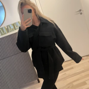 Kort kappa - Säljer min svarta kappa från Gina Tricot i strl XS. Använd sparsamt. Sidofickor, knappar att stänga med alternativt stänga med skärpet runt midjan. Lite längre baktill. Jätte fin o skön nu till hösten. Köptes för 500kr säljes för 250kr.