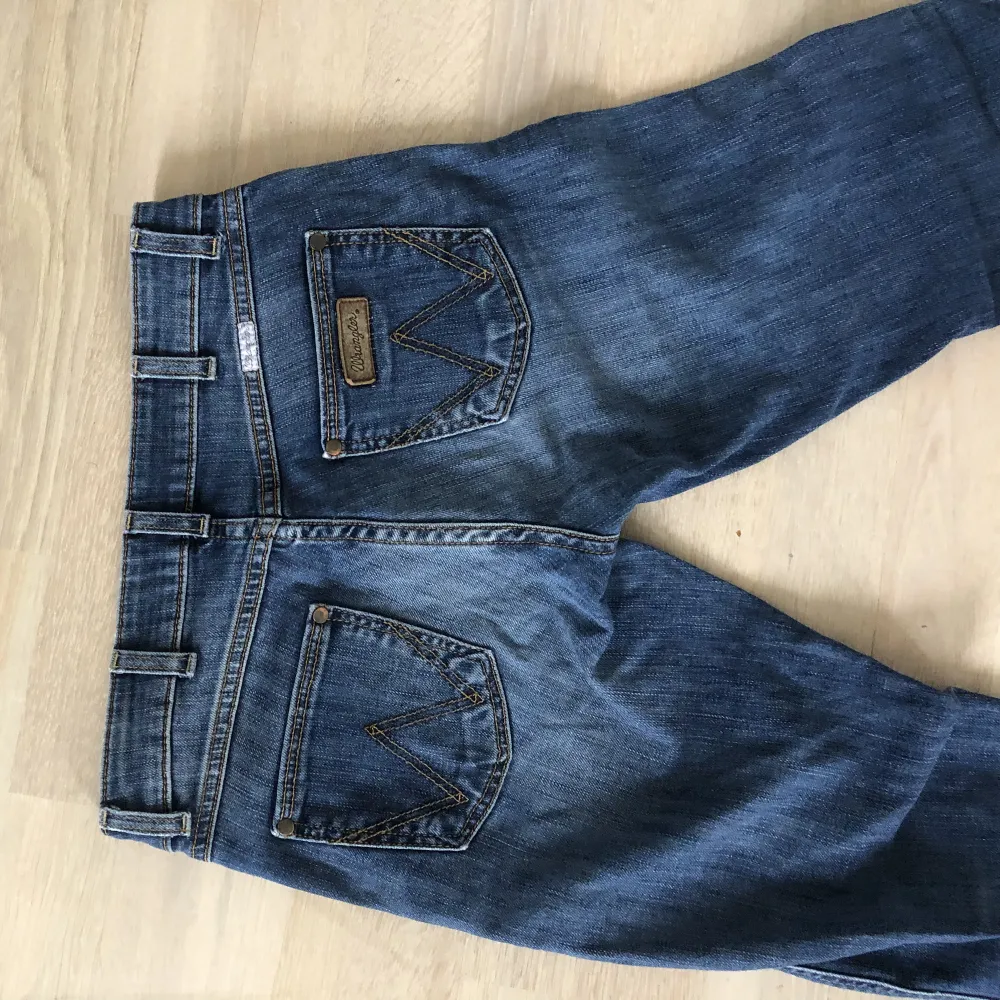 Lågmidjade bootcut jeans strl 27/34 från Wrangler. Mörkbkå, Färgen visar sig bättre på de närmre bilderna de är inte så mörka som de ser ut på helhetsbilden.. Jeans & Byxor.