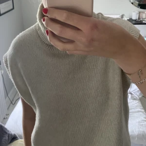 Stickad tröja  - En stickad polo ”väst” i beige/rosa ton. Jätteskön och sticks inte alls! Kommer ej till användning längre. 