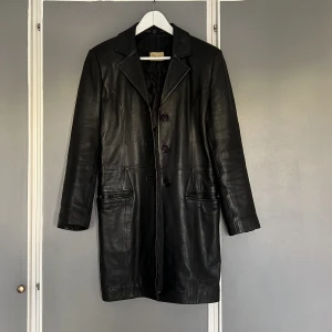 Vintage skinnkappa - Skinnkappa vintage 90-tal Svart kappa i äkta skinn med fin patina. Damstorlek S. True to size skulle jag säga. 