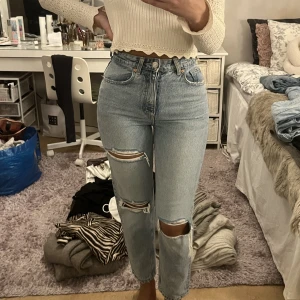 Högmidjade ripped jeans - Ett par högmidjade jeans köpt från zara. Storlek 34. Färgen är missvisande på bilden, dom är ljusblåa och INTE grå i tonen. Jätte fina byxor tyvärr har dom blivit små på mig. Använd några ggr, fortfarande som nya.