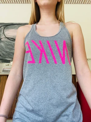 Linne från nike - Ett grått linne med rosa text från NIKE. Aldrig använt, linnet är i storlek S.