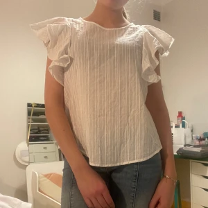 Vit blus - Jätte fin vit blus med knäppning i ryggen och volang armar 