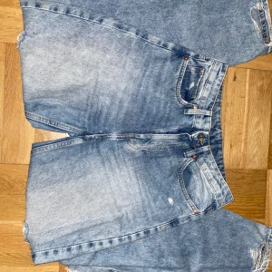 Jeans - Högmidjade jeans med hål. Använda men hela.  Baggy.