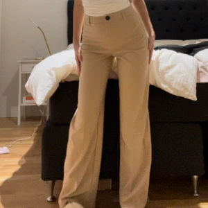 Beige kostym byxor - Säljer dessa vida beige kostym byxor från bershka. Dessa är högmidjade och flare. Endast använt ett par gånger. 
