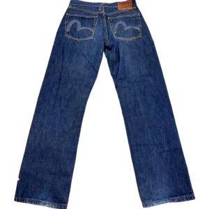 Evisu Baggy Jeans - Ett par Evisu jeans i baggy/straight passform med broderi på bakfikorna. Jeansen är i mycket bra skick utan fläckar eller skador. Jeansen är i storlek 32 men passar lite mindre. Känn dig fri att fråga du undrar något!