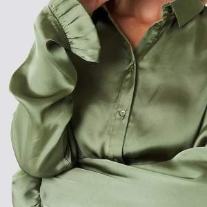Grön satin skjorta/blus med jätte fina volangärmar. Storlek XS men skulle säga att den är mer som en S💫