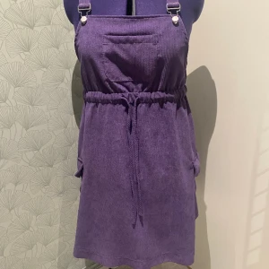 Hängselkjol i Manchester  - Hängselkjol i Manchester i mkt fint skick. 2 Stora fickor på sidorna och en på bröstet. 