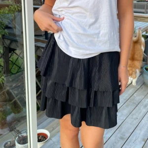 Svart volangkjol - Svart volangkjol från Sigal Dekel. Storlek XS men stretchig sä sitter t.ex bea på mig som är en S/M