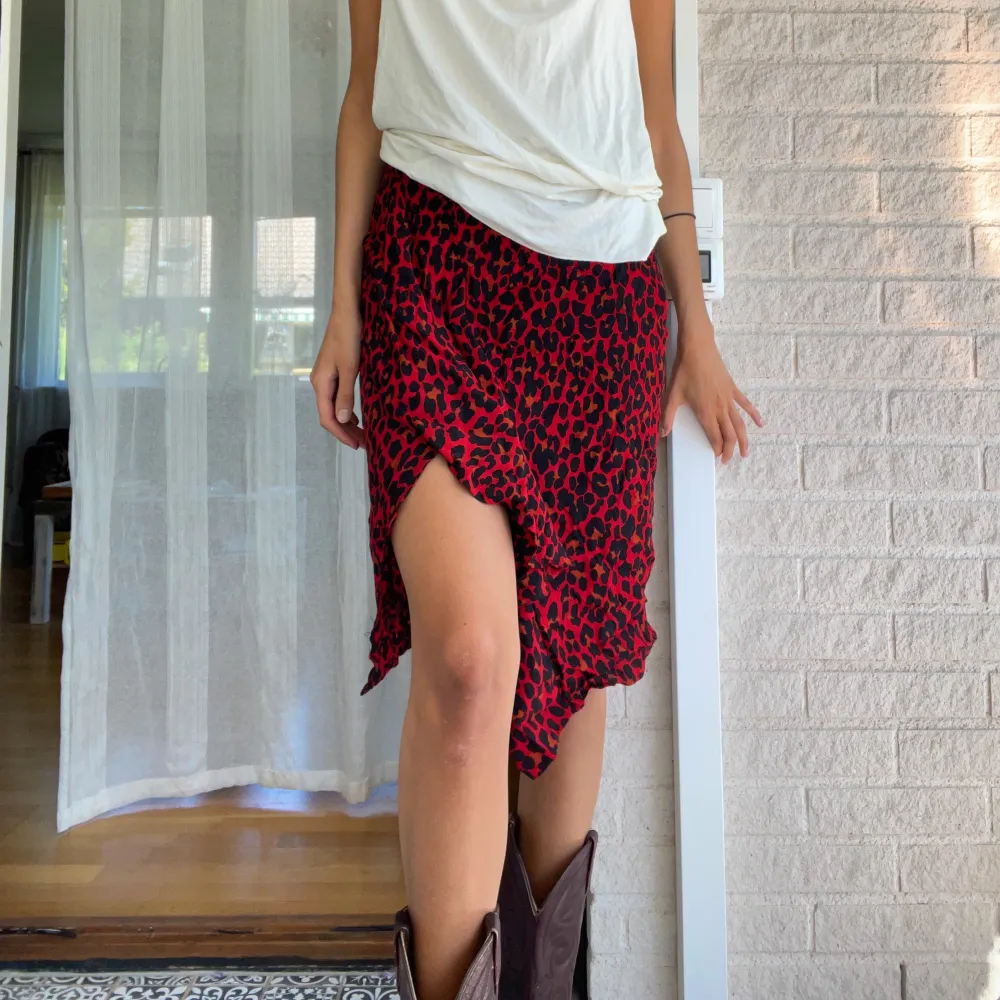 En leopardmönstrad röd kjol köpt på zara för några år redan! Den har en slits och volanger! sitter midwaist och har en dragkedja på sidan! Storlek M! Jag är 178 cm!. Kjolar.