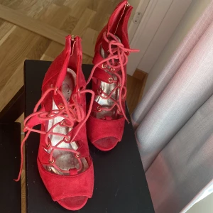 Röda klackar  - Jätte fina röda klackar aldrig använda i storlek 36 med fin snöre detalj, klacken är 10cm . Fler bilder kan skickas på begäran 