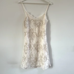 Vit mini spetsklänning  - Spetsklänning med broderade detaljer. Fint skick. 