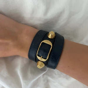Balenciaga armband  - Skitsnyggt mörkblått Balenciaga armband med guldiga detaljer. Köpt på plick innan, så tyvärr tillkommer ingen låda eller något till. Superbra skick allmänt! 