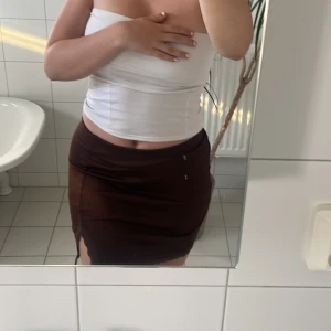 Brun kort kjol med slits - Fin kort kjol från hm som endast är använd några få gånger. I bra skick! Jag har M och skulle säga den passar både M och S