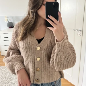 Stickad tröja med knappar - Varm stickad cardigan med knappar. Storlek 34/36 men skulle säga att den är närmare en större M. 