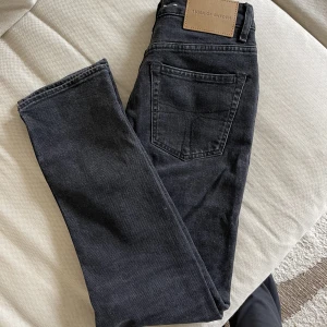 Tiger jeans i nyskick! - Säljer mina gråa jeans från Tiger i så gott som oanvänt skick då de är för stora för mig! Jättesnygg mörkgrå tvätt! Modellen Meg i storlek 26/30 normala i storlek