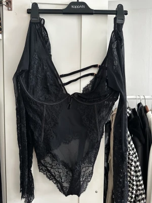 Svart spetsig Bodysuit - Säljer min svarta bodysuit med spets, aldrig kommit till användning/ aldrig använd.   Liten i storlek då jag brukar vara M  