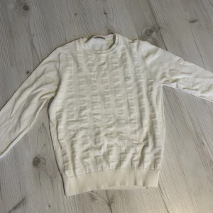 Stickad lacoste tröja - En fin stickad tröja från Lacoste som är i perfekt skick.