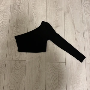 Svart topp - Svart enaxlad topp i gott skick. Använd 2 gånger. Pris kan diskuteras.