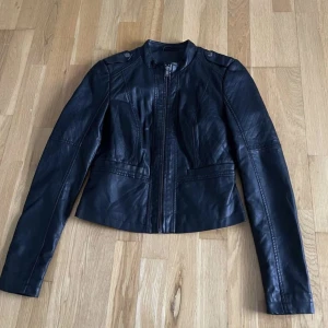 Skinnjacka - Skinnet är inte äkta, har använts och är på bra skick. Men snälla måste jag säga mer, skinn jackor är det bästa som finns, köp medans du har chansen 🤩