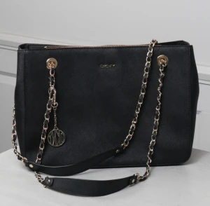 DKNY handväska  - Säljer denna fina dkny väska i använt skick, väskan har ett slitage på en av väskans kant nertill ( en liten öppning) säljs billigt pga det!🤍