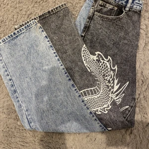 Jeans  - Ett par skit snygga jeans, ena benet är blått och det andra mörk grått med en kinesisk drake på🩵🩶🐉 Har bara haft på mig de typ en gång, så de är i princip typ oanvända, skriv om du vill ha mer specifika mått på byxorna🌸Prisändring kan ske vid snabbt köp