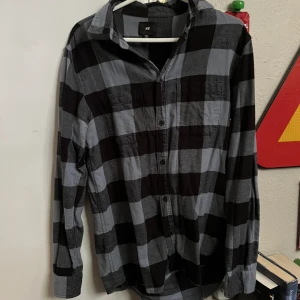 Ruting Blå Skjorta - Blå ruting skorta i bomull, som är lite tjockare i tyget så perfekt nu inför hösten!  Liten fläck på framsidan men som knappt syns