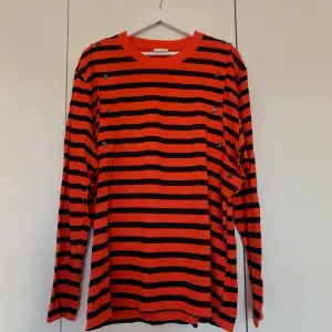 Never been used orange and black striped H&M studios T-Shirt in a thicker cotton quality. Oversized and removable sleeves with buttons on each arm. 