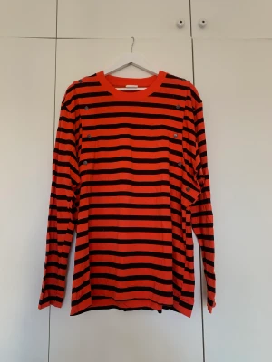 Striped long sleeve T-Shirt - Never been used orange and black striped H&M studios T-Shirt in a thicker cotton quality. Oversized and removable sleeves with buttons on each arm. 