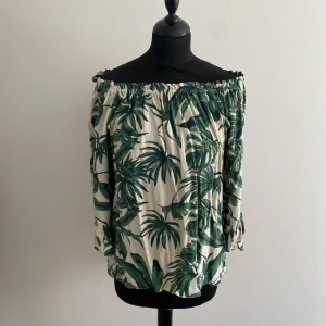 Mönstrad blus  - Blus i lös modell från HM med trekvarts ärm och resår i halsringning. Går att använda både av och på axlar. Strl 34 men passar även 36. 