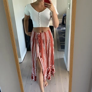 Randig långkjol - Randig somrig midikjol med resår i midjan! Köpt från fashionnova för längesen. Storlek XS. Skriv för fler bilder!