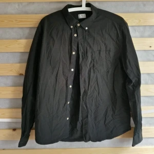 Mörkgrön Asketskjorta - Bomullsskjorta från Asket i mörkgrönt. Tätt och bekvämt tyg. Säljes pga lite kort i ärmarna.