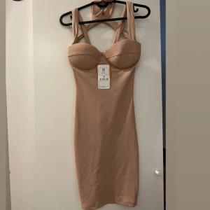 Beige väldigt sexig klänning - Helt oanvänd beige sexig klänning som aldrig tyvär kunnat komma till användning med tanke på att den vart för liten på mig vid brösten men annars sitter väldigt snyggt på i storlek M