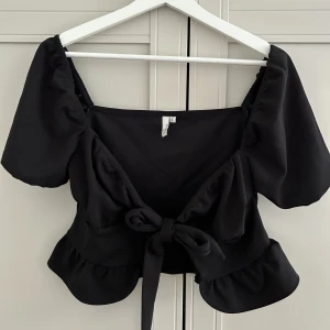 Svart knyt topp - Jättegullig knyt topp från Nelly. Aldrig använd! Nypris 349kr