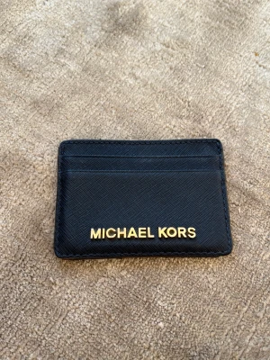 Michael kors korthållare  - Fin blå korthållare med guldtext. Lite sliten uppe på men inget som stör.