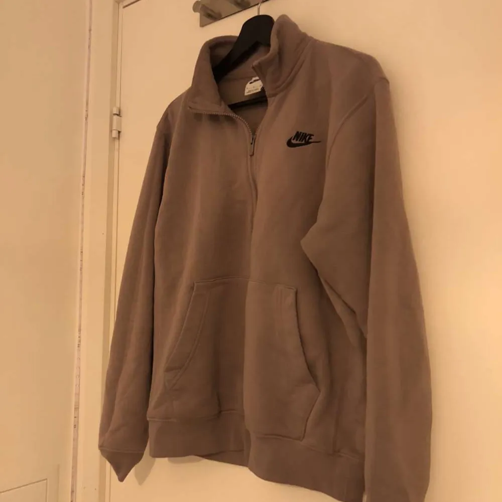 En brun/beige 1/4 zip kofta från Nike herr avdelningen: Köpt vintern 2021/22 men den har inte kommit till någon användning. Inga skador finns. Den är väldigt mjuk inuti och även tjock i material. Tröjan är i storlek S men kan även passa någon med M.. Tröjor & Koftor.