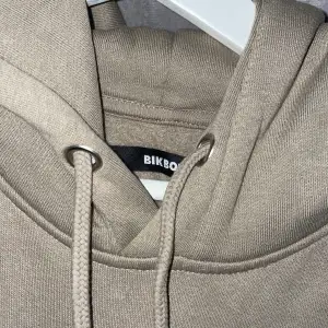 Knappt använd hoodie från BikBok i beige/grön färg. Köpt för 400kr