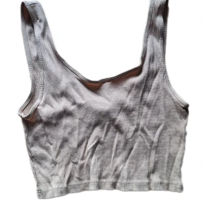 Crop top - Beige croppat linne i ribbat material. Köpte på Sellpy för nåt år sedan men använde det aldrig. Kan skicka fler bilder privat. Färgen är lite mer varm beige än på bilden.