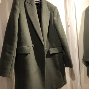 Grön kappa  - Fin grön halvlång kappa från mango. Storlek M. Något liten i storleken. Är själv vanligtvis en storlek S-M.  Endast använd ett fåtal gånger och i mycket bra skick 