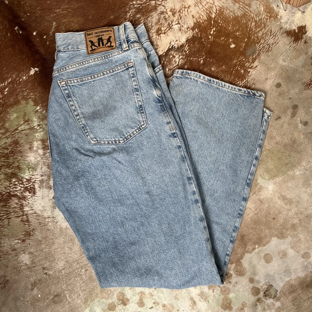Ljusblåa baggy jeans ifrån sweet sktbs bara använt 3-4 gånger, dem är i fint skick. Jag är en s i vanliga fall och sitter bra i midian, är 168cm lång. Jeans & Byxor.