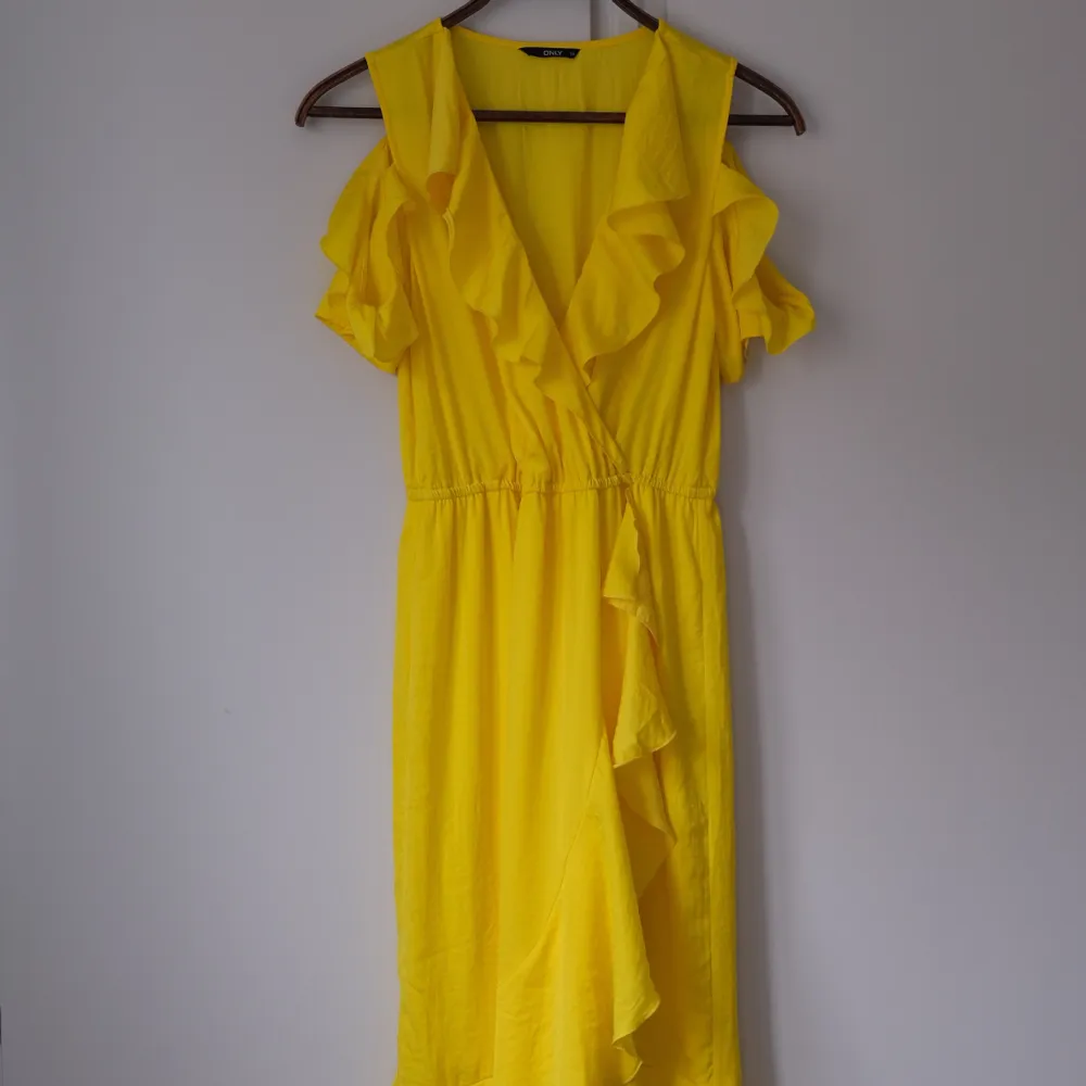 Fin gul sommarklänning endast använd ett fåtal gånger och i perfekt skick. En klänning med ”hål” för axlarna och som går ner till mitten på vaden. . Klänningar.
