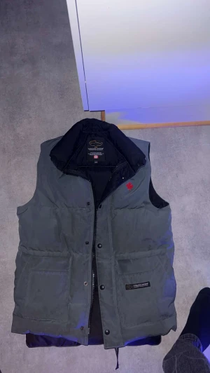 Canada goose väst - Säljer en canada goose väst gammal modell, storlek xs/tp Grå färg väldigt svår att få tag på, kemtvätt behövs.